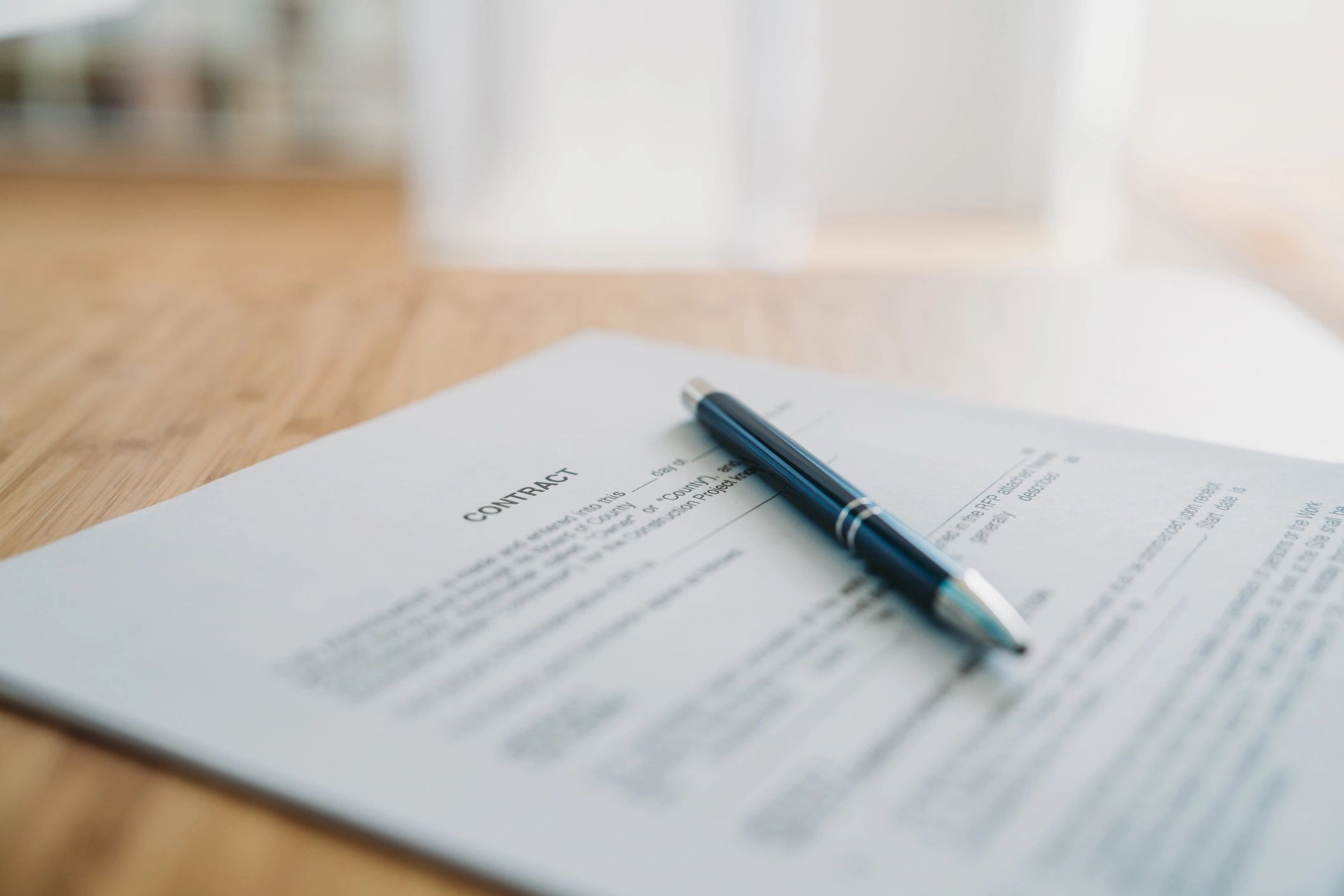 Contract document on a desk with a pen